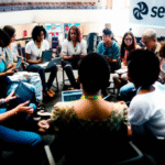 Jovens em roda com laptops no Desafio Liga Jovem Sebrae, representando a educação empreendedora e o futuro do MEI em 2025